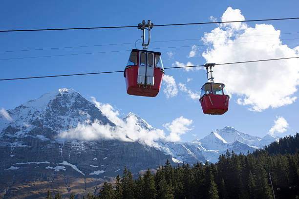 Schilthorn Gondola Cable Car riding over Lauterbrunnen Valley between Stechelberg, Mürren and Piz Gloria. Scenic summer evening view of Swiss Alps and Jungfrau Mountain in the background.