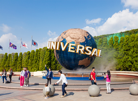 Osaka, Japan - October 27, 2014: View of tourists and Universal Globe outside the Universal Studios Theme Park in Osaka, Japan. The theme park has many attractions based on the film industry.