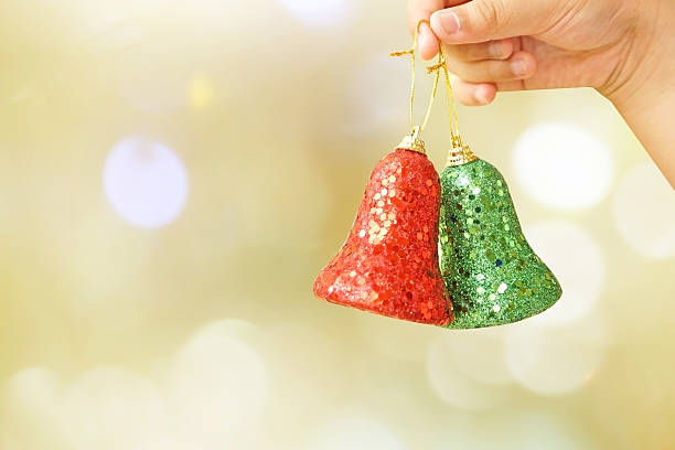 istock Child holding golden Christmas tree decorations on lights background 526041965