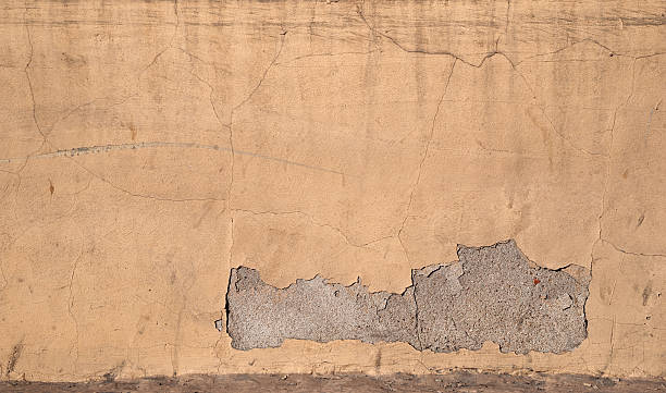 istock Texture of old wall covered with yellow stucco 526055081