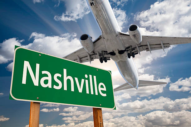 Nashville Green Road Sign and Airplane Above Nashville Green Road Sign and Airplane Above with Dramatic Blue Sky and Clouds. tennessee road sign stock pictures, royalty-free photos & images