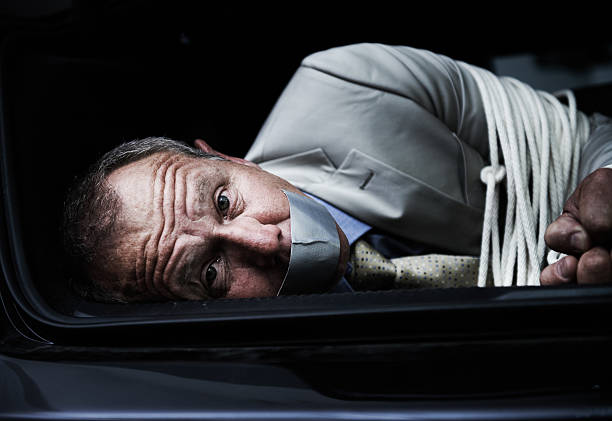 Help me... Portrait of a frightened businessman lying bound and gagged in the trunk of a carhttp://195.154.178.81/DATA/shoots/ic_782198.jpg in bounds stock pictures, royalty-free photos & images