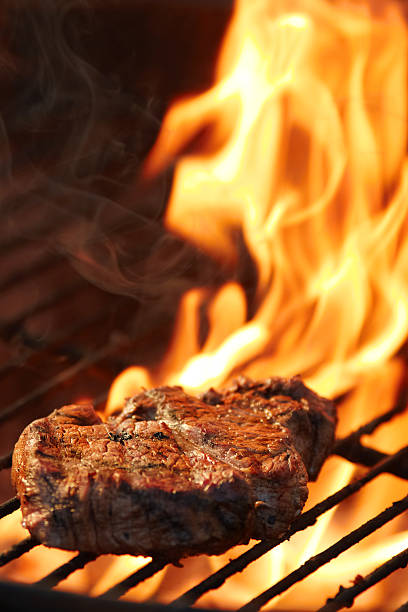 Delicious steak on grill with flames