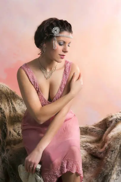 Closeup in vintage colors of a 1920s style young woman with diamond headdress and flapper dress