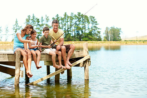 la pêche est toujours un moyen de se détendre - fishing father son family photos et images de collection