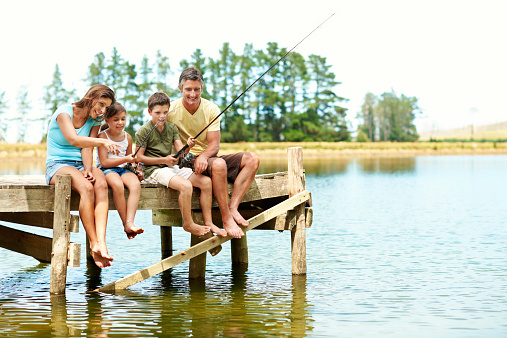 Shot of a family of four fishing together