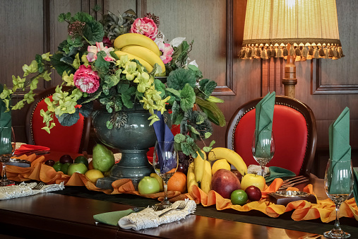 Colorfully arranged wooden table with fruits and flowers in restaurant