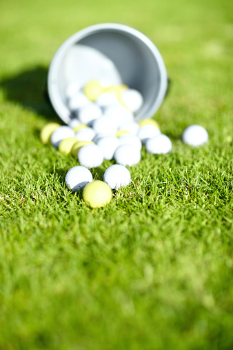 Shot of a bucket of golf balls on a golf course