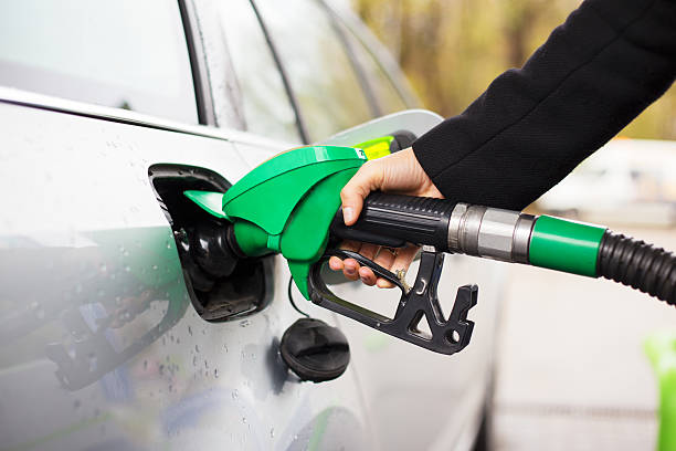 Hand holding fuel pump und unbegrenzt Auto an Tankstelle – Foto