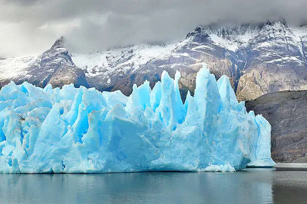 Blue icebergs and snowy mountains at Grey Glacier in Torres del Paine National Park, Patagonia, Chile