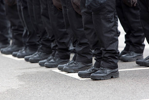 Policemen legs and boots Policemen's black uniforms and boots in line. security staff photos stock pictures, royalty-free photos & images