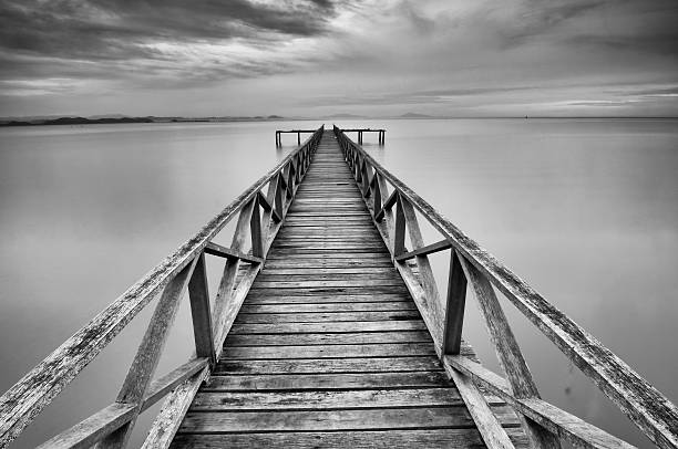Calm scene of abandoned jetty at Teluk Tempoyak Calm scene of abandoned jetty at Teluk Tempoyak black and white beach stock pictures, royalty-free photos & images