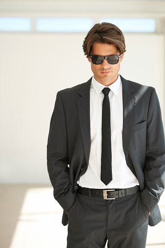 Portrait of a handsome young businessman in a suit and wearing sunglasses