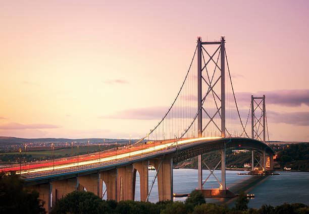 forth road bridge, au crépuscule - rivière firth of forth photos et images de collection