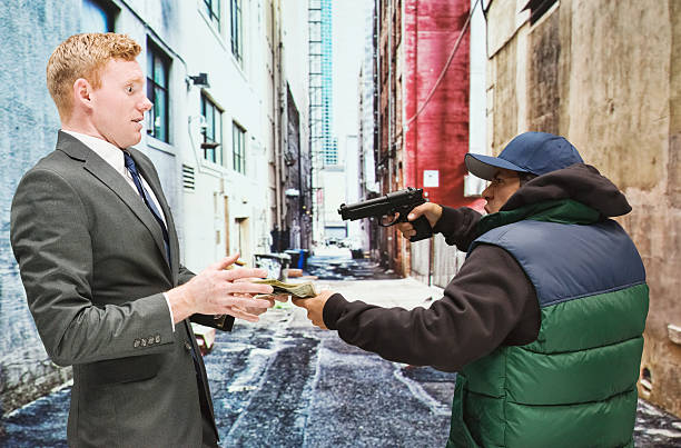 istock One guy with gun robbing man in the suit 526086195