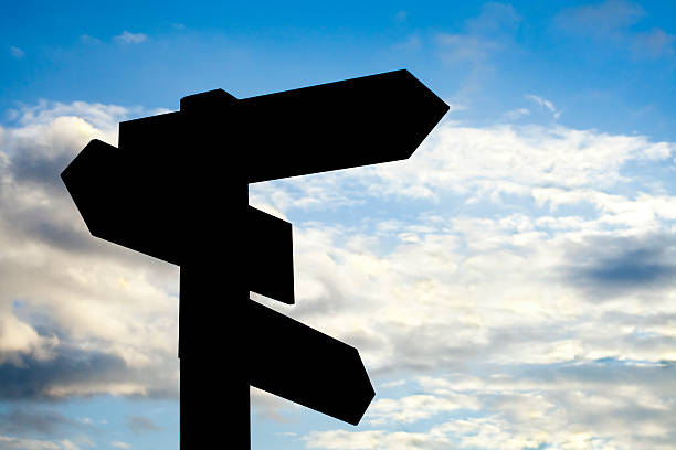 istock Silhouetted wooden sign post and cloudscape. 526088043