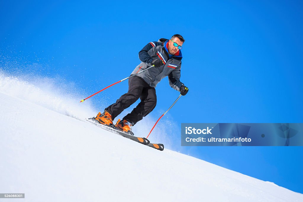 Mid adult  men snow skier skiing on sunny ski resorts Mid adult  men snow skier skiing, enjoying on sunny ski resorts. Skiing carving at high speed against blue sky. Shot with Canon 5DMarkIII, developed from RAW,  Adobe RGB color profile. Shallow DOF  for soft background. 30-34 Years Stock Photo