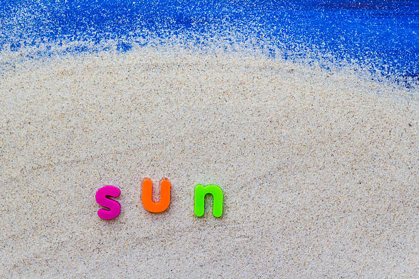 palabra de sol sentado arena azul de - sandy brown fotos fotografías e imágenes de stock
