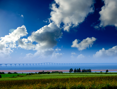 Confederation bridge at Prince Edward Island, Canada with a hay field in foreground.