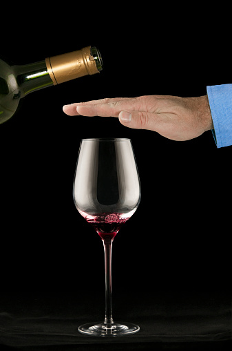 Man's hand refusing to accept more wine in his glass