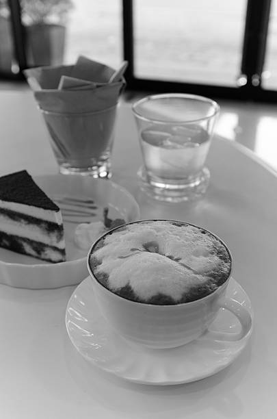 istock cup of cappuccino with tiramisu cake on table 526115447