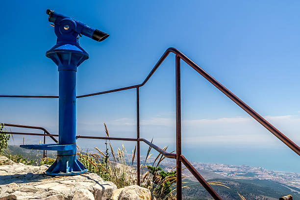 istock blue binoculars and a view of the coast and sea 526115563