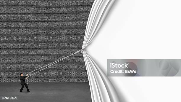 Businessman Pulling Down White Curtain Covering Old Dark Brick W Stock Photo - Download Image Now