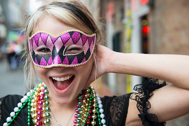 Fun-loving young woman at Mardi Gras in New Orleans Louisiana A young woman on Bourbon Street during Mardi Gras in New Orleans, Louisiana new orleans mardi gras stock pictures, royalty-free photos & images