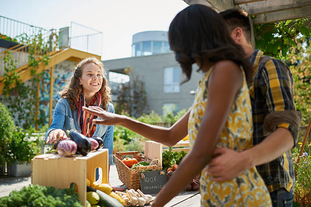 istock Friendly woman tending an organic vegetable stall at a farmer 526124862