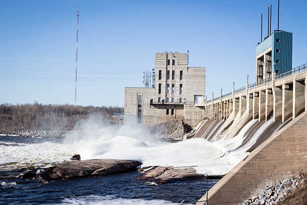 istock huge water dam with water gushing over turbines. 526127288