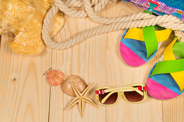 istock beach bag, flip flops, sunglasses,  on wooden background. Top view 526127740