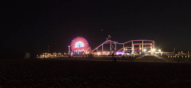 paseo a lo largo de la playa de santa mónica iluminadas por la noche - santa monica pier beach panoramic santa monica fotografías e imágenes de stock