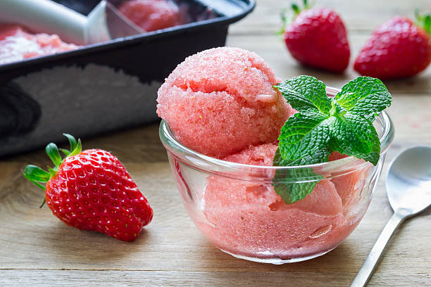 Homemade strawberry sorbet in glass on a wooden table stock photo