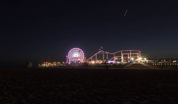 promenade sur la jetée de santa monica de nuit illuminée - ferris wheel santa monica pier santa monica wheel photos et images de collection