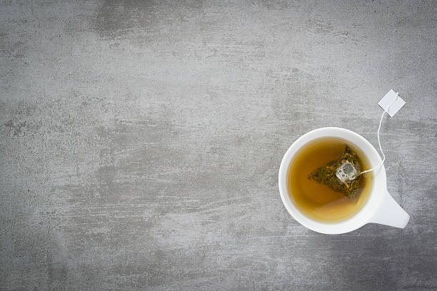 Cup of tea with teabag Cup of tea with teabag, on concrete stone background camellia sinensis photos stock pictures, royalty-free photos & images