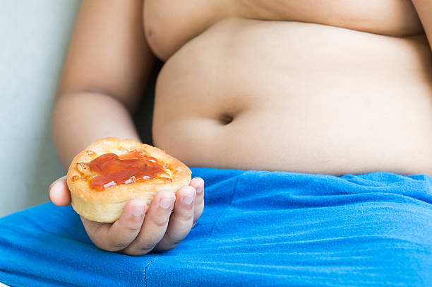 istock small pizza in obese fat boy hand. 526140568