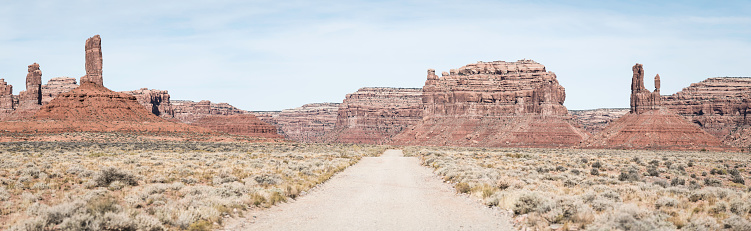 Long straight desert road disappearing into the iconic sandsctone mesas and buttes of Monument Valley, Utah, USA. ProPhoto RGB profile for maximum color fidelity and gamut.