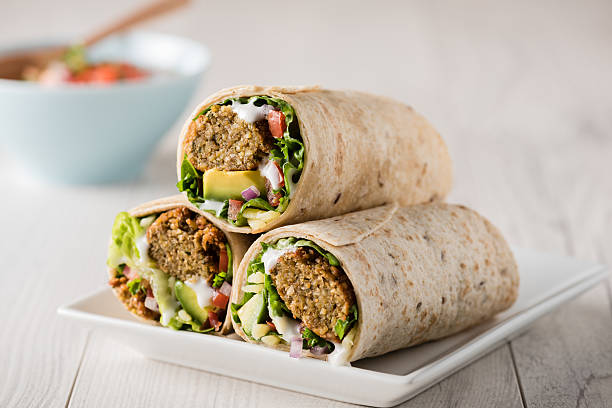 Vegetarian falafel wraps Vegetarian falafel wraps with avocado and cheese tortilla flatbread stock pictures, royalty-free photos & images