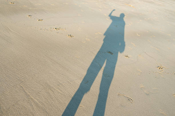 istock shadow of the man on the sandy beach 526142530