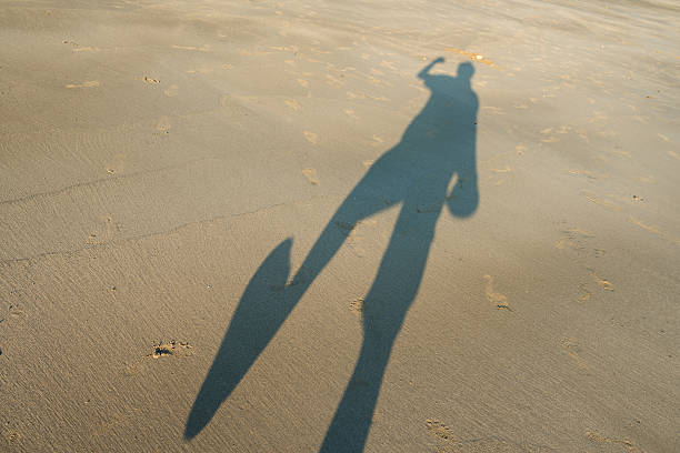 istock shadow of the man on the sandy beach 526142678