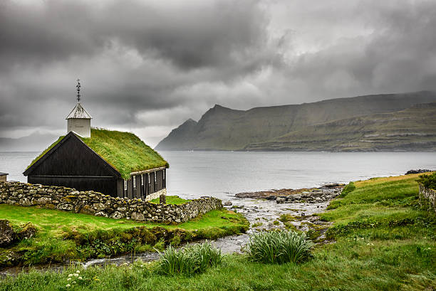Small village church under heavy clouds Small village church in Funningur under heavy clouds. Funningur is located on the island of Eysturoy, Faroe Islands, Denmark eysturoy photos stock pictures, royalty-free photos & images