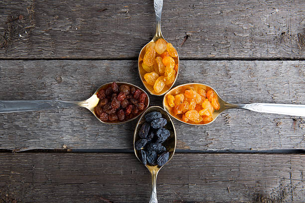 istock raisins in metal spoons on wooden table 526146102