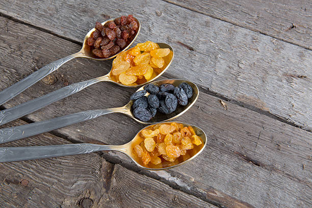 istock raisins in metal spoons on wooden table 526146534
