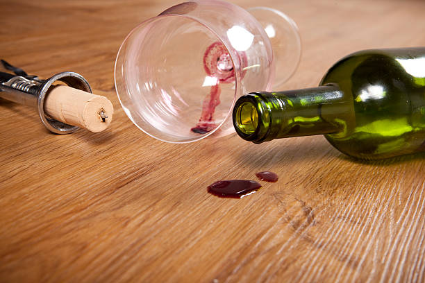 red wine stain with empty bottle, dirty wine glass, corkscrew red wine stain on wooden flooring, with dirty wine glass, corkscrew and empty wine bottle, wine glass knocked over stock pictures, royalty-free photos & images