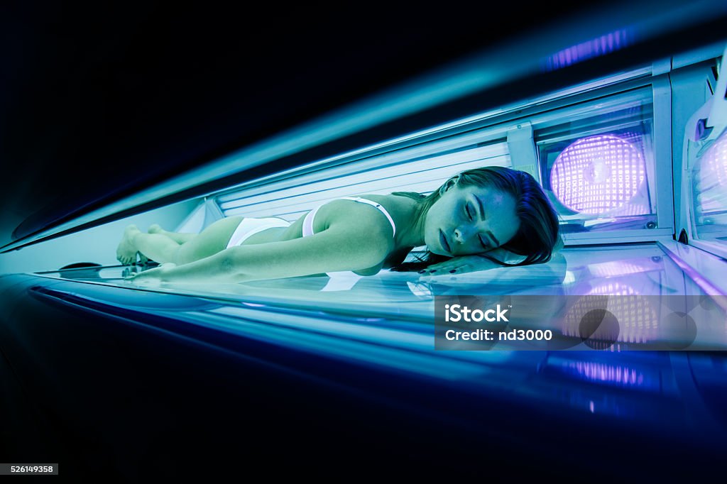 Beautiful woman lying in solarium Beautiful woman lying in solarium and sunbathing Tanning Bed Stock Photo