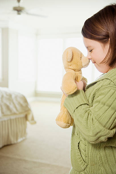 istock Girl kissing teddy bear 526149919