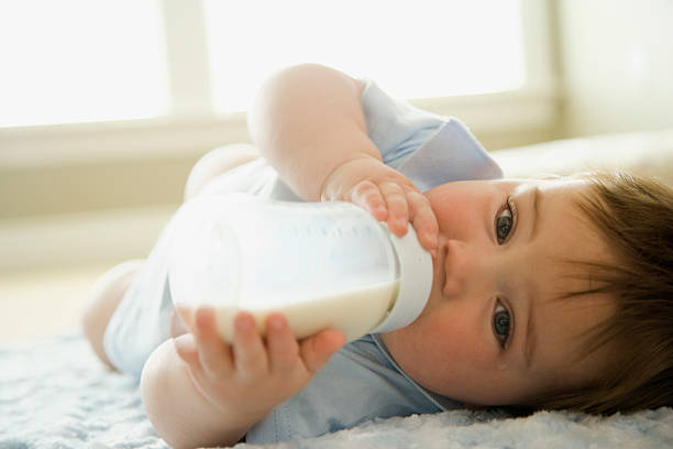 bebé niño bebiendo leche de cartón de leche - milk bottle fotos fotografías e imágenes de stock