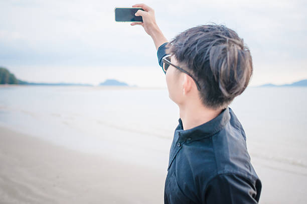 istock Business man working with smartphone beach background 526150858