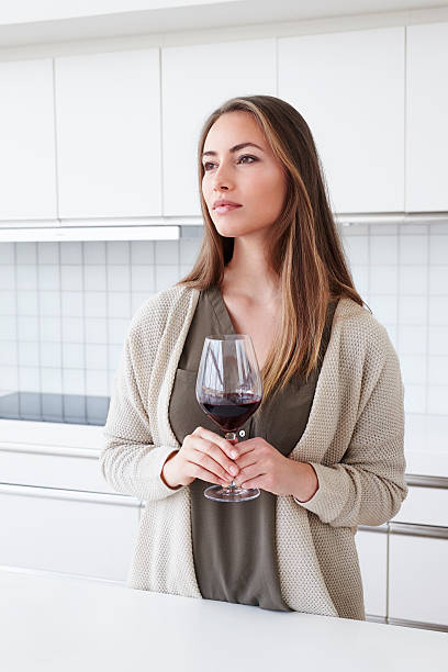 istock Beautiful woman in kitchen with wine 526152816