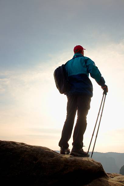 istock Hiker in windcheater, baseball cap and with trekking poles 526153968